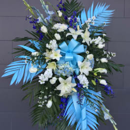 Large blue and white floral standing spray with ribbon on an easel