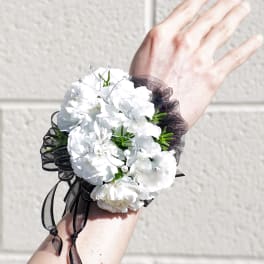 White carnation wrist corsage with black ribbon