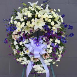 Large white and purple funeral wreath with a lavender ribbon