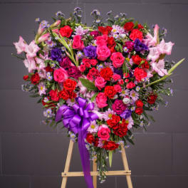 Heart-shaped floral spray with pink and red roses on an easel