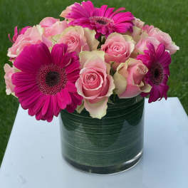 Pink roses and magenta gerbera daisies in a glass vase