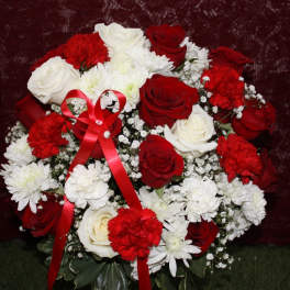 Red and white rose bouquet with carnations and a red ribbon