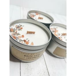 Three white sage and lavender tin candles with wood wicks and crystal and herb toppings