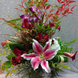 Tall bouquet of pink lilies, red roses, and purple orchids