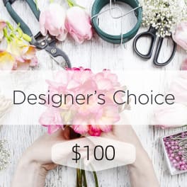 Designer’s choice floral arrangement with pink blooms and florist tools on a white surface
