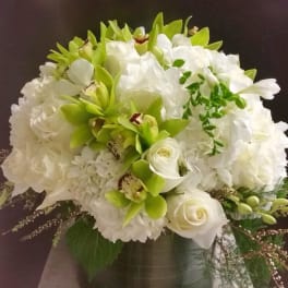 White and green floral arrangement in a dark vase