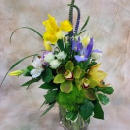 Mixed bouquet with yellow and purple flowers in a glass vase