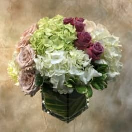 Bouquet of hydrangeas and roses in a square glass vase