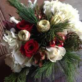 Bouquet of red and white roses with pine branches and pinecones