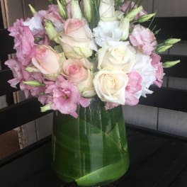 Pink and white roses with lisianthus in a glass vase