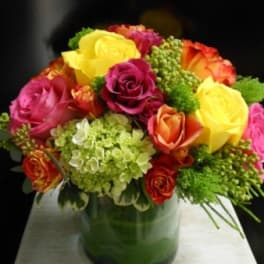Colorful rose bouquet in a green glass vase