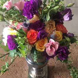 Colorful bouquet of roses and lisianthus in a silver vase