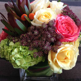 Bouquet of cream and pink roses with green hydrangea in a glass vase