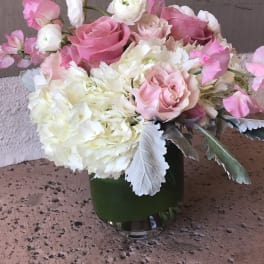Pink and white floral arrangement in a glass vase