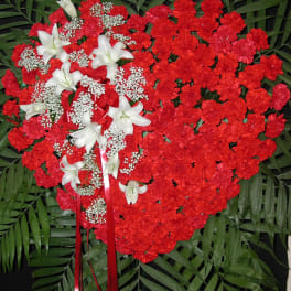 Heart-shaped red carnation spray with white lilies and ribbon