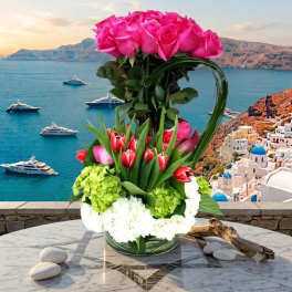 Tall bouquet of pink roses and red tulips in a glass vase