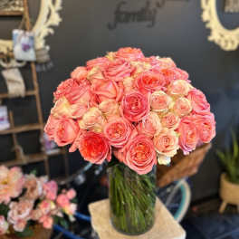 Bouquet of pink and peach roses in a clear glass vase