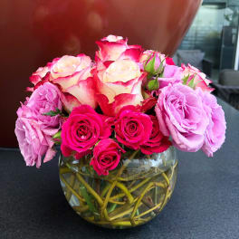 Pink and cream roses arranged in a clear glass vase
