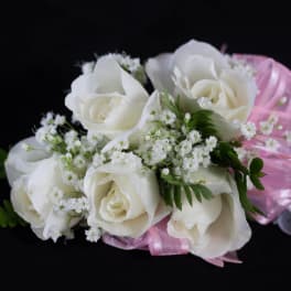 White rose corsage with baby's breath and pink ribbon