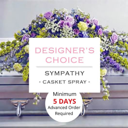 Purple, yellow, and white sympathy casket spray on a silver casket