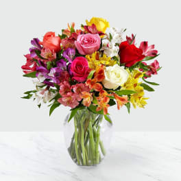 Mixed bouquet of roses and alstroemeria in a clear glass vase