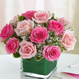 Pink and blush roses arranged in a square glass vase