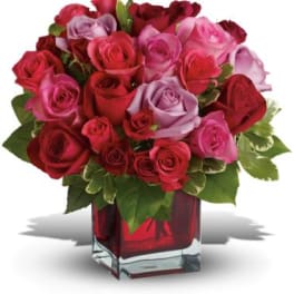Bouquet of red and pink roses in a red glass vase
