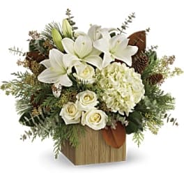 White lilies and roses arranged in a wooden box
