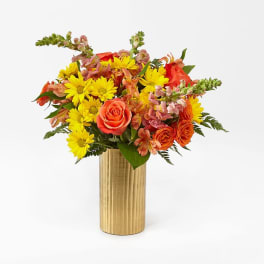 Bouquet of yellow daisies and orange roses in a gold vase