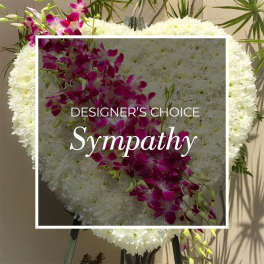 White sympathy floral wreath with a diagonal spray of purple orchids