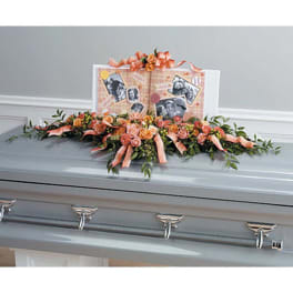 Peach floral casket spray with ribbon and photo display