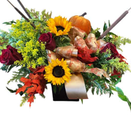 Autumn bouquet with sunflowers, red roses, and a pumpkin in a black vase