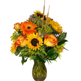 Sunflower and orange rose bouquet in a glass vase