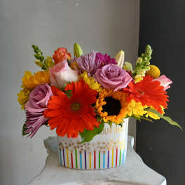 Colorful mixed bouquet in a white decorative container