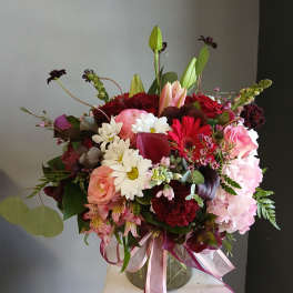 Mixed bouquet with lilies, roses, daisies, and hydrangeas in a glass vase