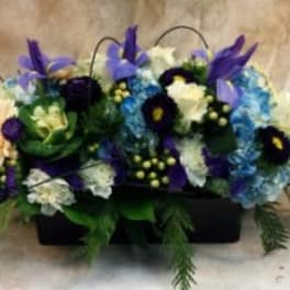 Mixed blue, purple, and white floral arrangement in a black container