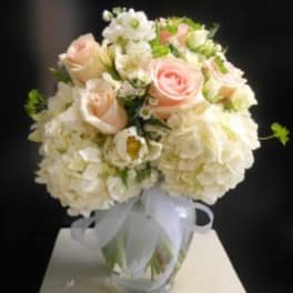 Bouquet of pale pink roses and white hydrangeas in a glass vase