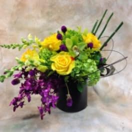 Yellow and purple floral arrangement in a black vase