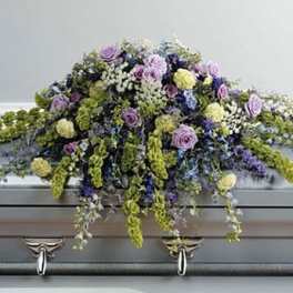 Lavender and white floral casket spray with trailing blooms