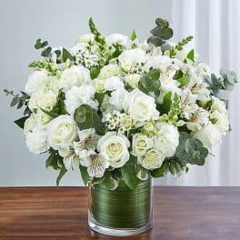 White roses and mixed white flowers in a glass vase