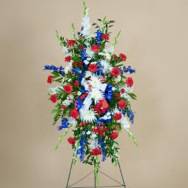 Tall red, white, and blue funeral spray on an easel