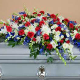Red, white, and blue funeral spray on a casket