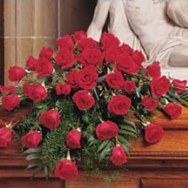 Red rose casket spray on a wooden casket