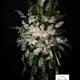 Tall white floral standing spray with lilies and ribbon streamers
