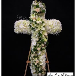White floral cross arrangement on an easel