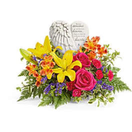 Bright mixed flower arrangement with angel figurine