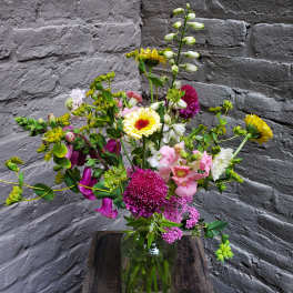 Mixed bouquet in a glass vase with pink, white, and yellow flowers
