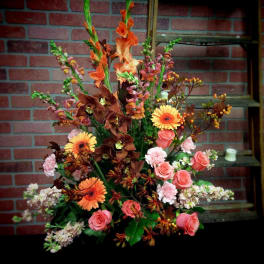 Tall mixed floral arrangement with orange, pink, and white blooms
