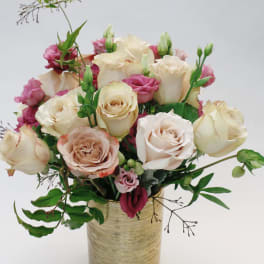 Bouquet of cream and pink roses in a gold vase