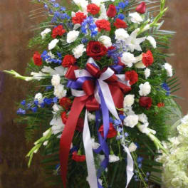 Standing floral spray with red, white, and blue flowers and ribbon